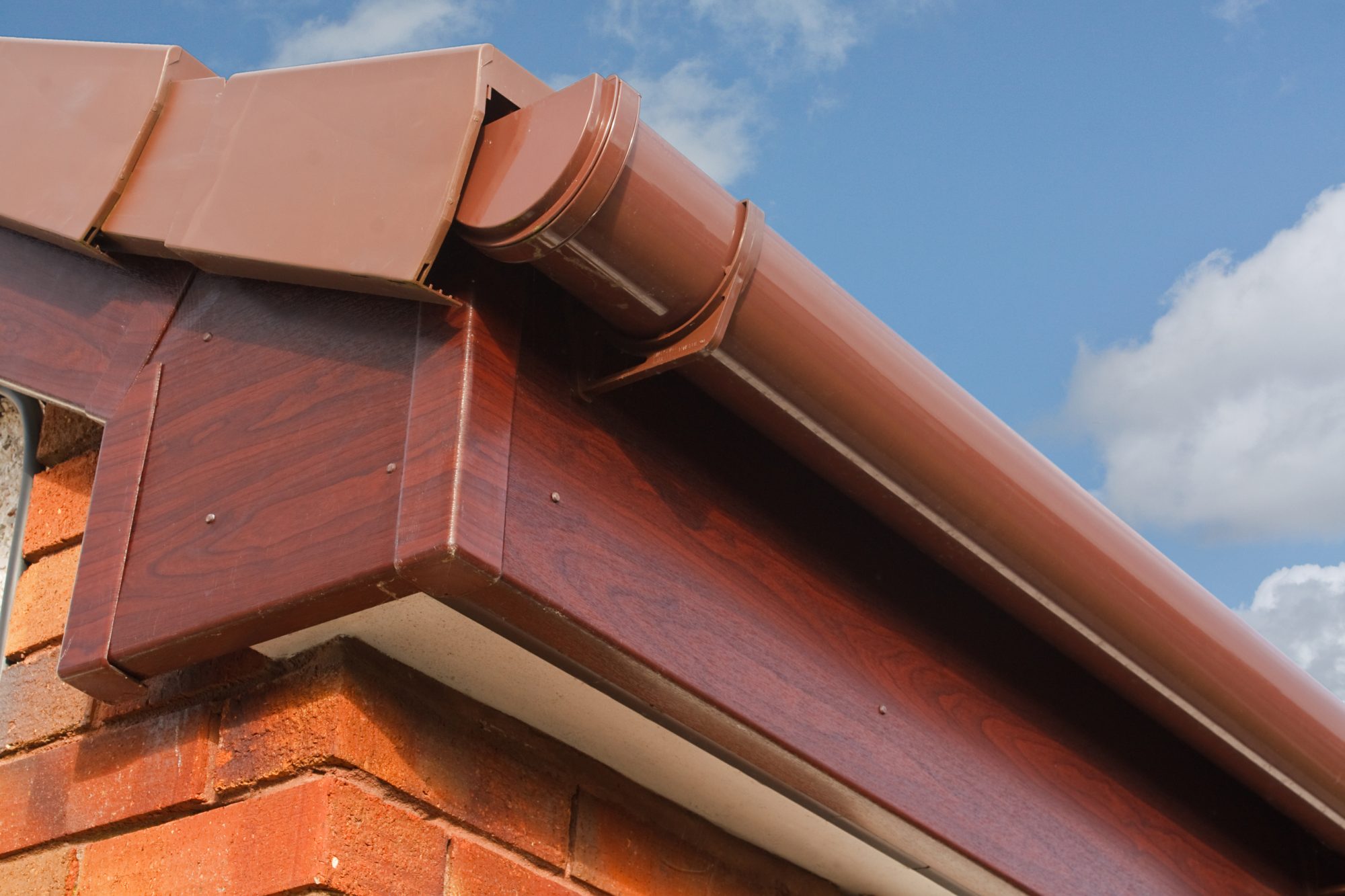 dreamstime_l_29357090 Close up of Brown wood effect PVCu or plastic soffit, fascia and guttering on modern new build residential property