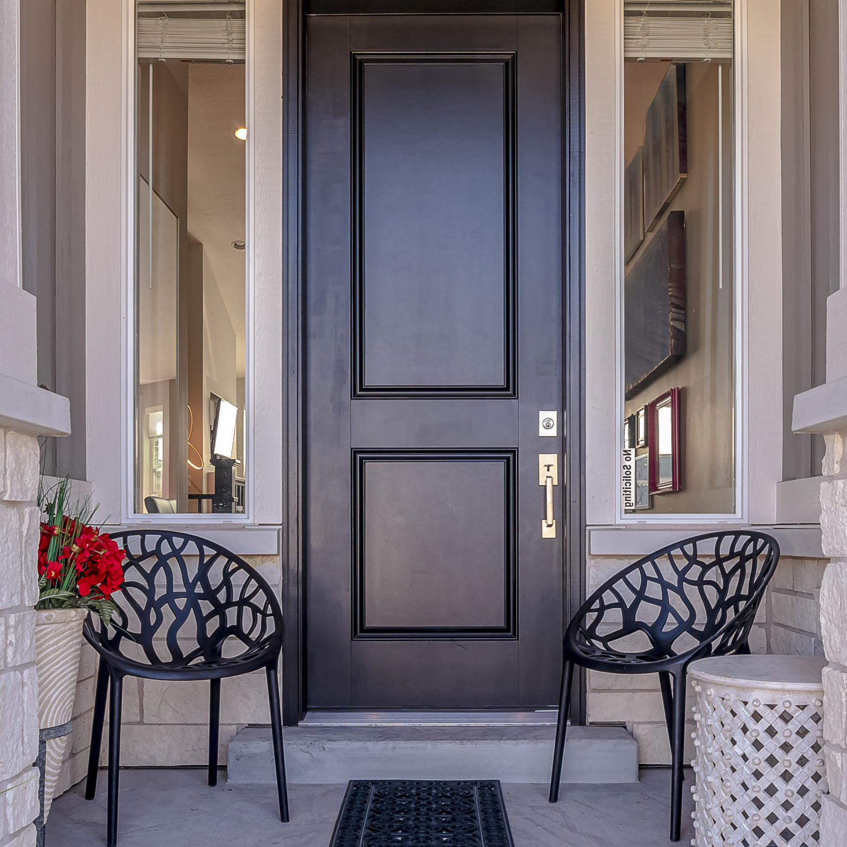 Square Path leading to front door of a residential house. Path leading to a front door of a residential house with covered porch with two chairs and mat and timber clad walls